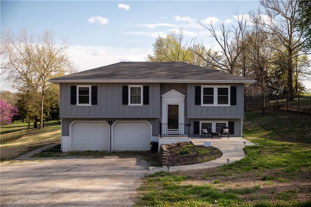 split foyer home featuring an attached garage, fence, and driveway