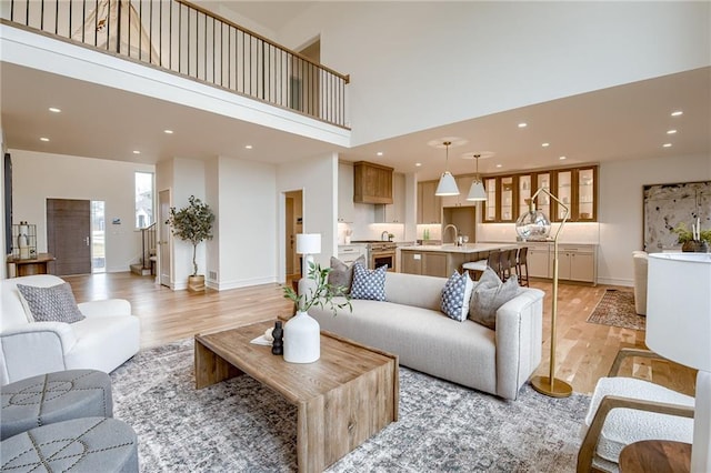 living room with a towering ceiling and light hardwood / wood-style flooring