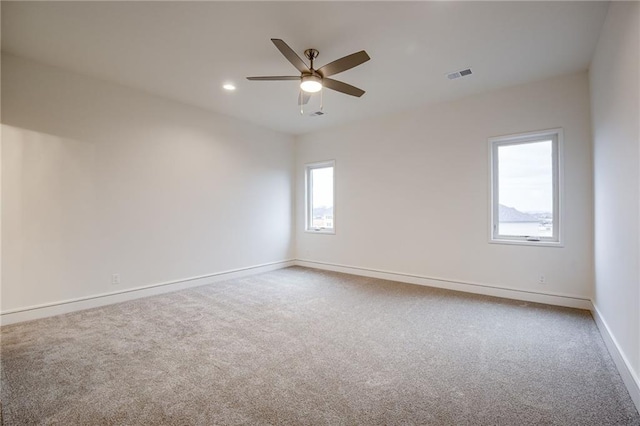 carpeted spare room with ceiling fan