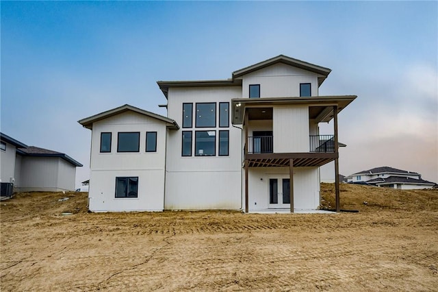 rear view of house featuring a balcony and central AC unit