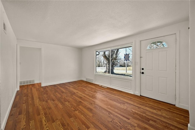 entryway featuring dark wood-type flooring and a textured ceiling