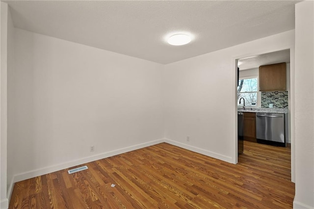 unfurnished room with dark hardwood / wood-style floors and sink