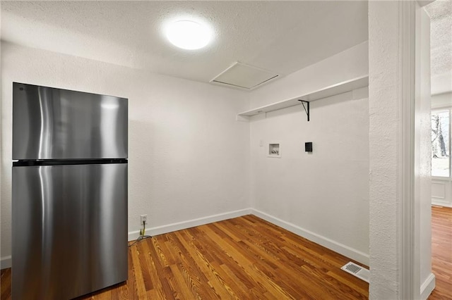 washroom with washer hookup, hardwood / wood-style floors, and a textured ceiling