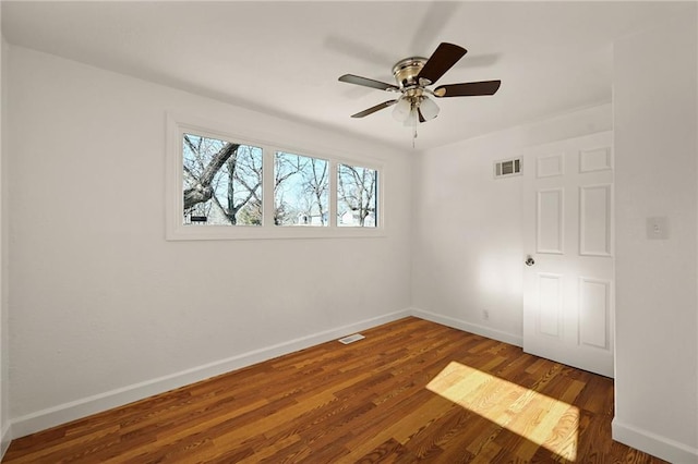 empty room featuring dark wood-type flooring and ceiling fan