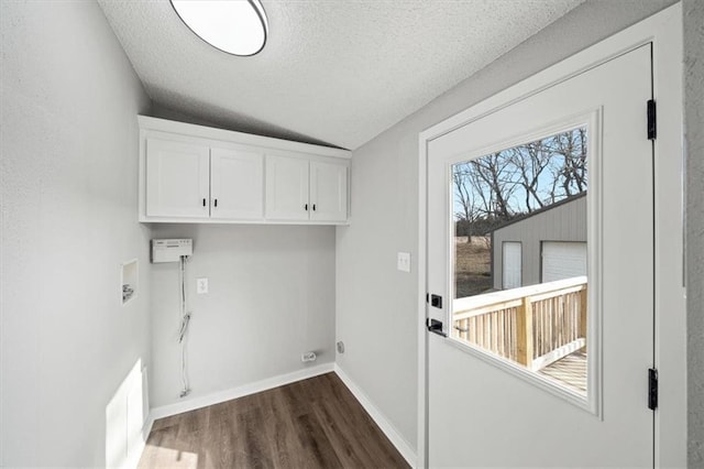 washroom featuring hookup for a washing machine, dark wood-type flooring, a textured ceiling, and cabinets