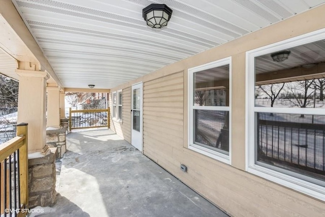 snow covered patio featuring covered porch