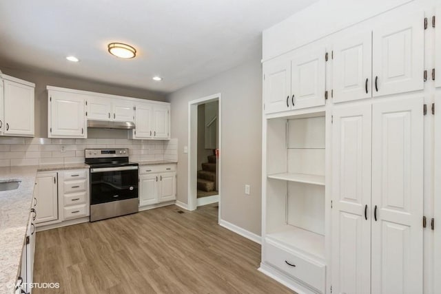 kitchen featuring light wood-type flooring, white cabinets, tasteful backsplash, and stainless steel range with electric cooktop