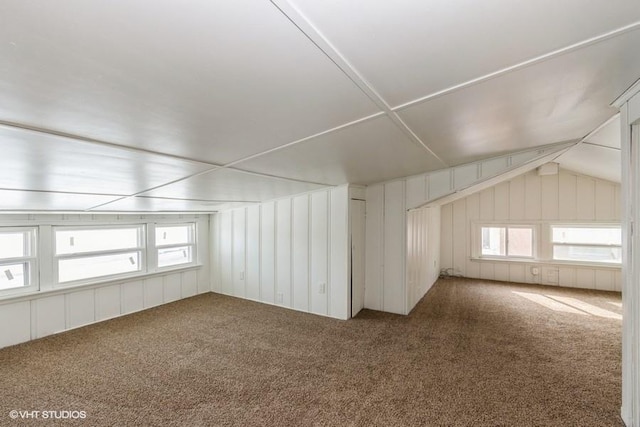 bonus room with vaulted ceiling and carpet