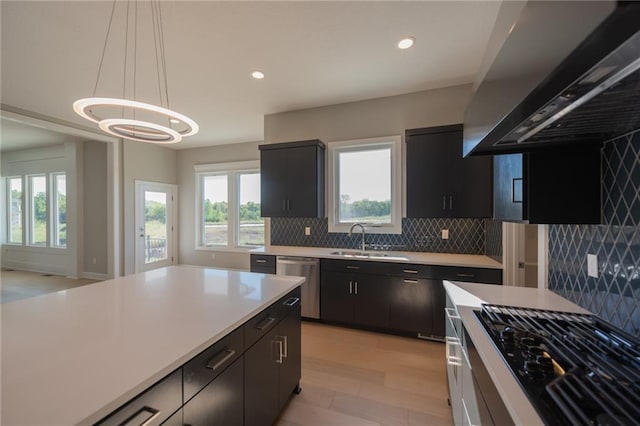 kitchen with dishwasher, sink, hanging light fixtures, plenty of natural light, and ventilation hood