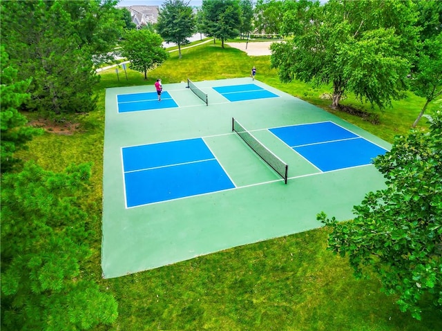 view of sport court featuring a lawn and basketball hoop