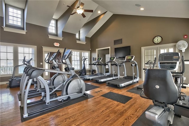 gym with high vaulted ceiling, hardwood / wood-style floors, and ceiling fan