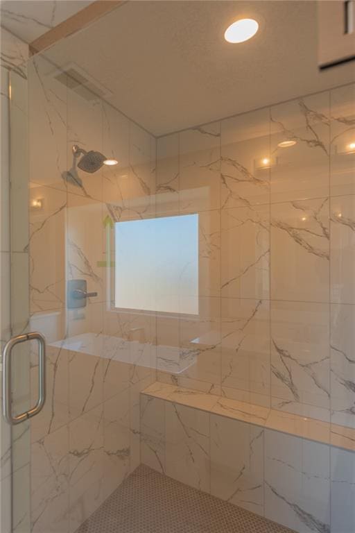 bathroom featuring a marble finish shower