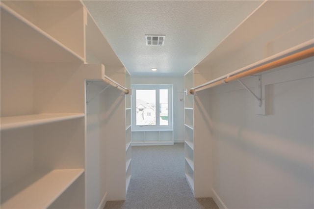 walk in closet featuring visible vents and carpet flooring