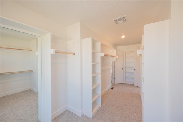 spacious closet featuring light carpet and visible vents