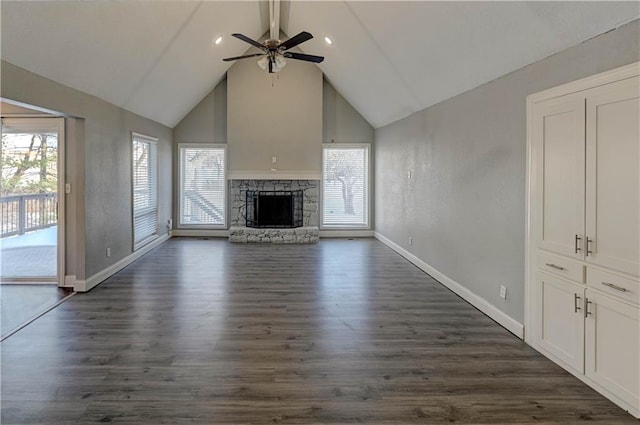 unfurnished living room featuring dark hardwood / wood-style flooring, plenty of natural light, and a stone fireplace