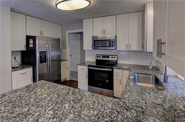 kitchen featuring backsplash, sink, white cabinets, and appliances with stainless steel finishes