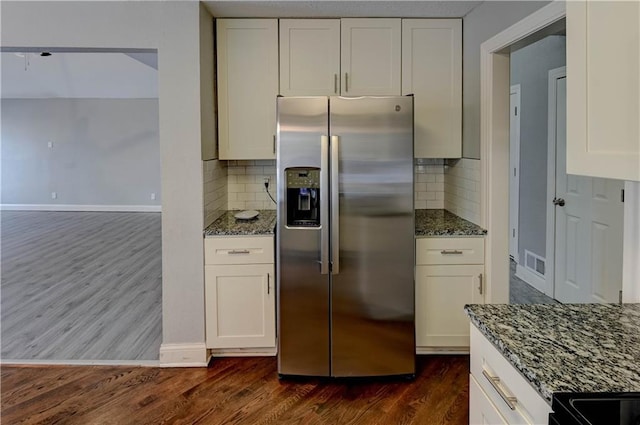 kitchen with white cabinetry, decorative backsplash, and stainless steel fridge