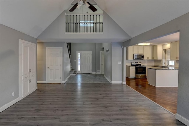 entryway featuring ceiling fan, dark hardwood / wood-style flooring, sink, and a high ceiling