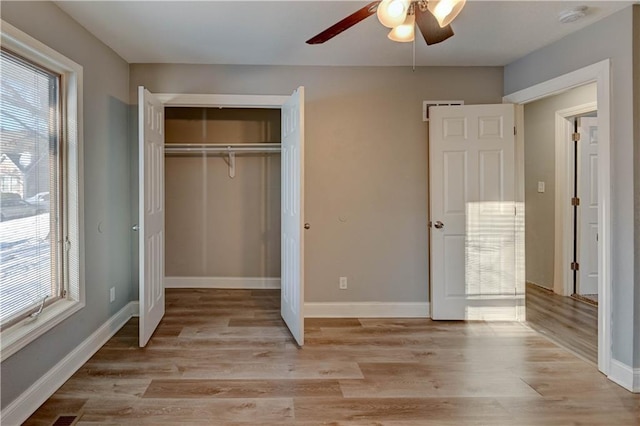 unfurnished bedroom with ceiling fan, multiple windows, and light hardwood / wood-style flooring