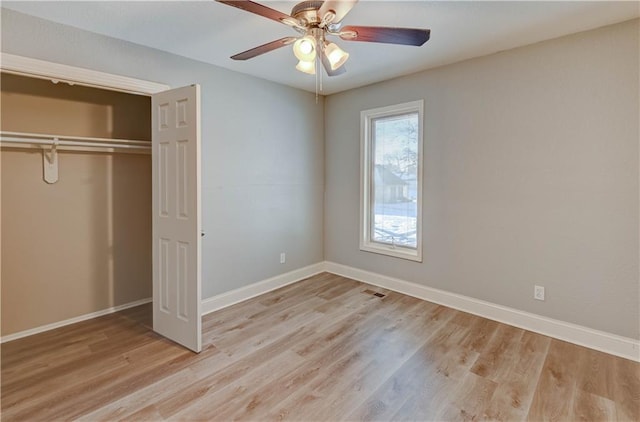 unfurnished bedroom with ceiling fan, light wood-type flooring, and a closet