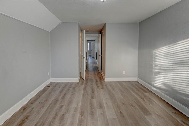 bonus room featuring lofted ceiling and light hardwood / wood-style floors