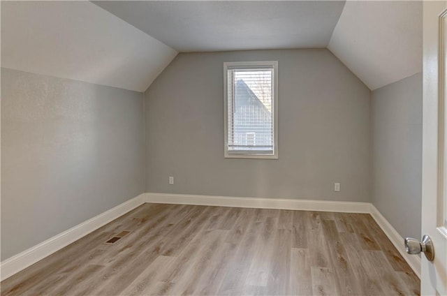 bonus room with light hardwood / wood-style flooring and lofted ceiling