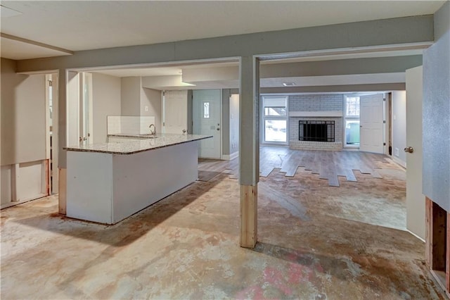 kitchen featuring a fireplace, white cabinets, and sink