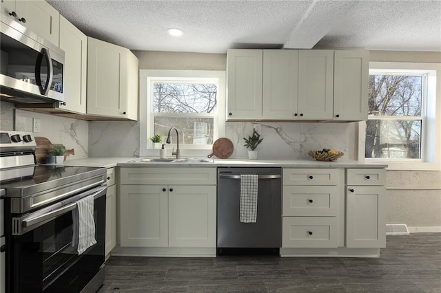 kitchen featuring sink, white cabinets, plenty of natural light, and stainless steel appliances