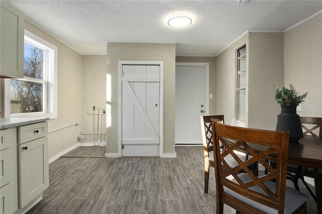 dining area with a textured ceiling, dark hardwood / wood-style flooring, and crown molding