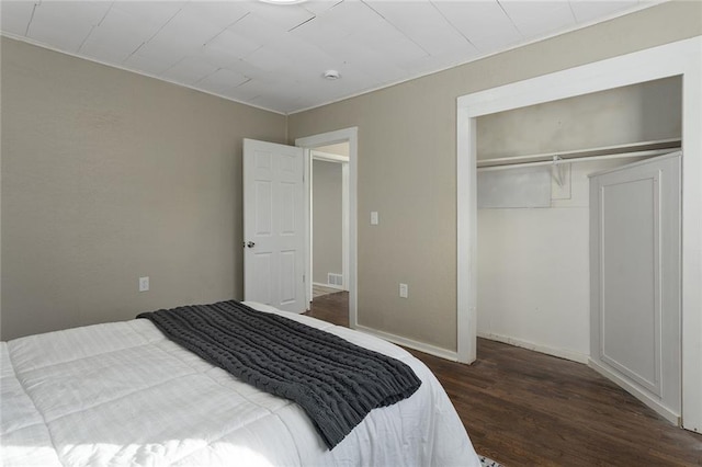 bedroom with dark wood-type flooring and a closet