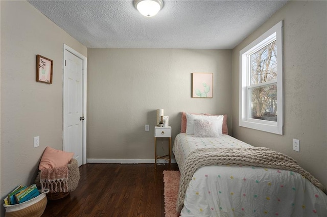 bedroom featuring dark wood-type flooring and a textured ceiling