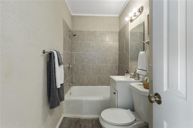 full bathroom featuring hardwood / wood-style flooring, toilet, tiled shower / bath, and vanity