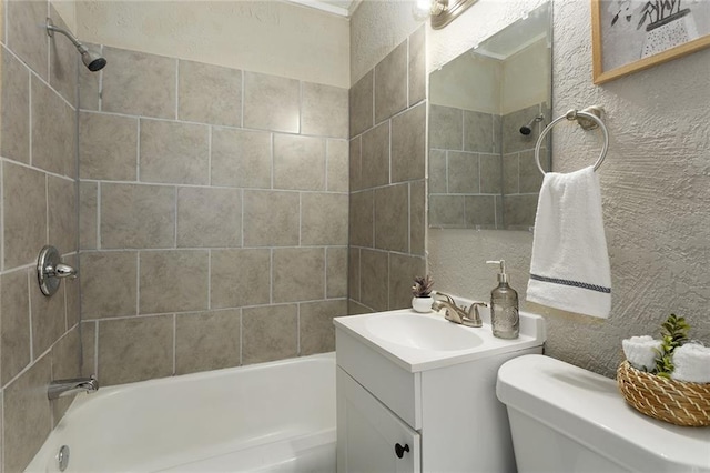 full bathroom with toilet, tiled shower / bath, and vanity