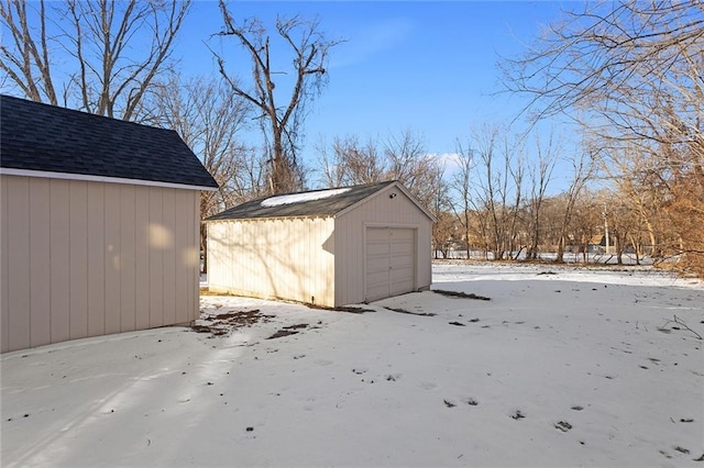 snow covered structure featuring a garage