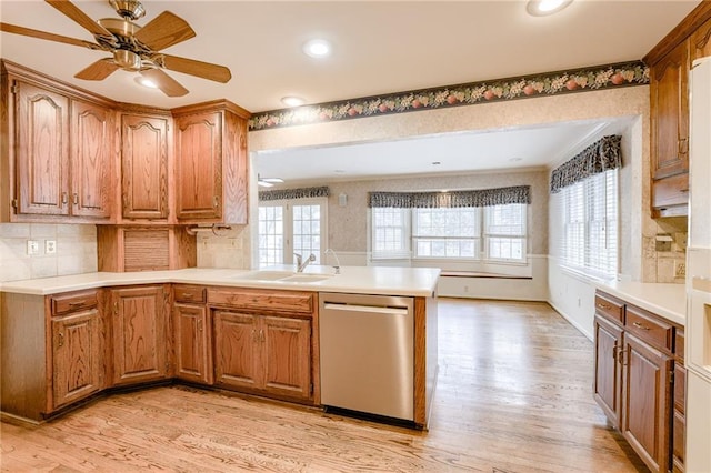 kitchen with kitchen peninsula, dishwasher, sink, and light hardwood / wood-style floors