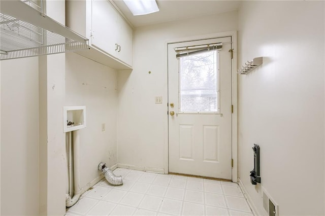 clothes washing area with cabinets