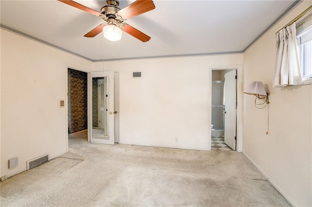 carpeted spare room with ceiling fan and crown molding