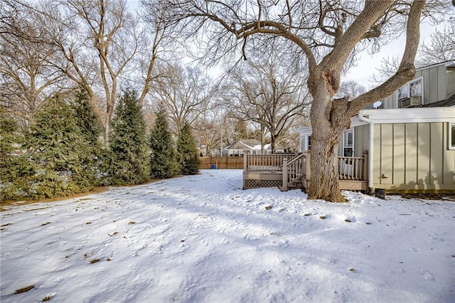 yard layered in snow with a deck