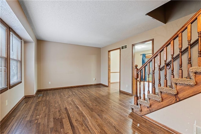 interior space featuring dark wood-type flooring and a textured ceiling