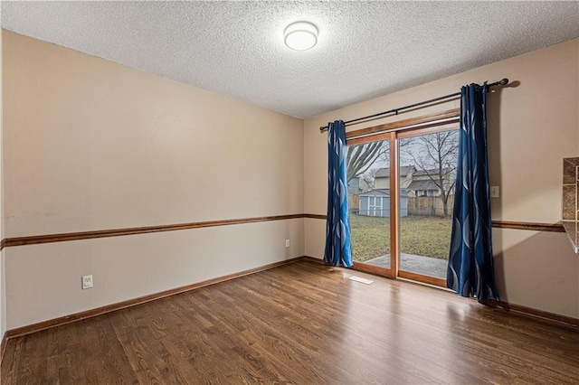 unfurnished room with hardwood / wood-style floors and a textured ceiling