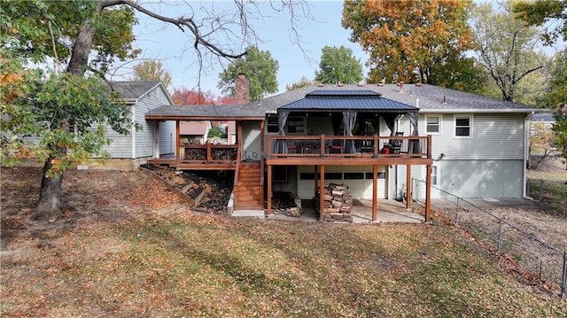 back of property featuring a wooden deck, a patio, and a lawn