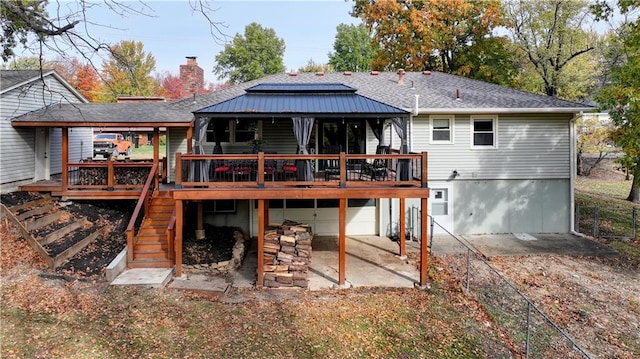 back of house featuring a garage, a patio, and a deck