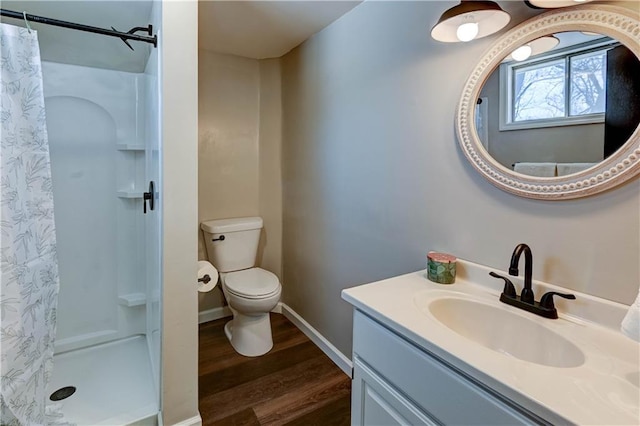 bathroom featuring wood-type flooring, curtained shower, vanity, and toilet