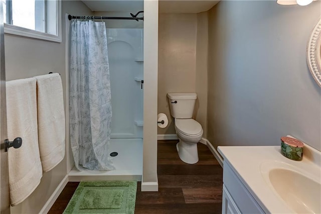 bathroom featuring a shower with curtain, vanity, hardwood / wood-style flooring, and toilet