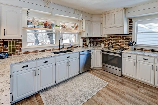 kitchen featuring white cabinetry, stainless steel appliances, light hardwood / wood-style floors, and sink