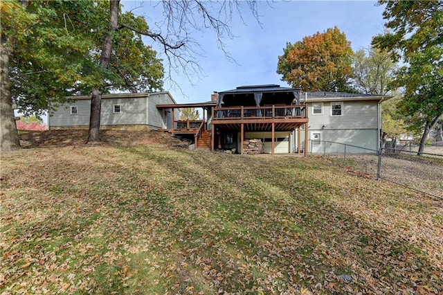 back of property featuring a wooden deck and a lawn