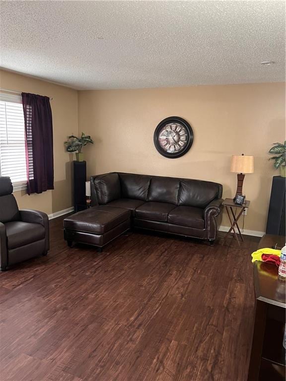 living room with dark wood-type flooring and a textured ceiling