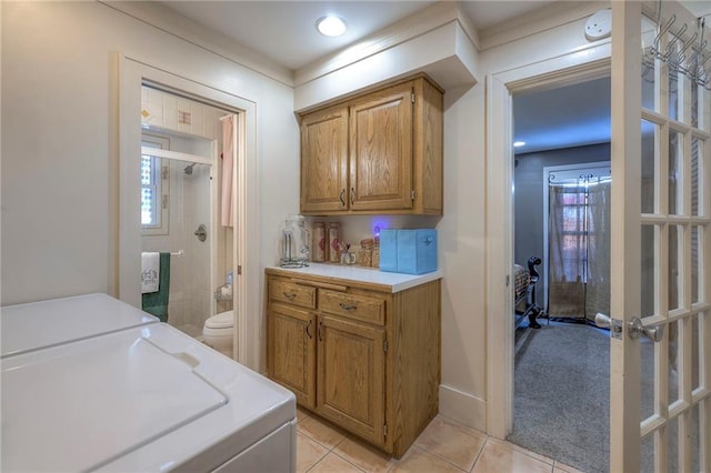 clothes washing area featuring cabinets and light tile patterned floors