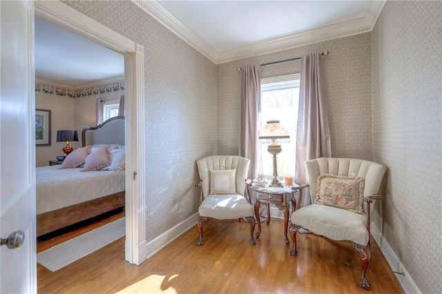 sitting room featuring crown molding and light hardwood / wood-style floors