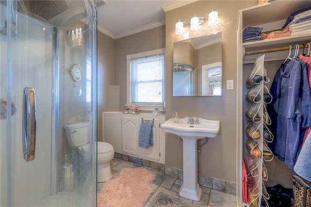 bathroom featuring crown molding, toilet, and a shower with shower door